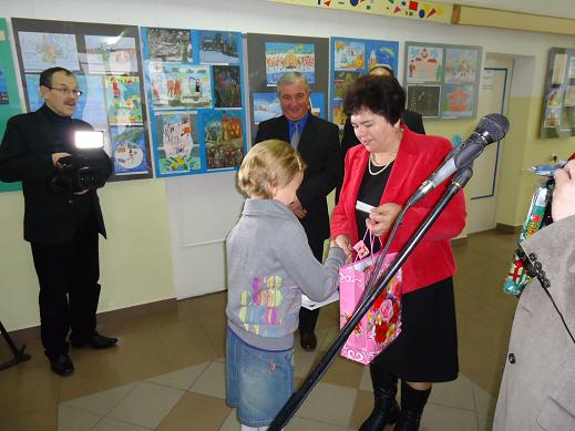 Wręczanie nagród laureatom konkursu plastycznego na kartkę bożonarodzeniową. Nagrodę przez siebie ufundowaną wręcza radna powiatu łomżyńskiego - Maria Mrozek.